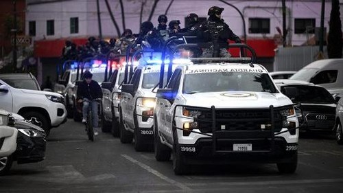 Mexican National Guard special forces patrol around the Specialized Prosecutors Office for Organized Crime (FEMDO) headquarters in Mexico City on February 22, 2026. Mexico confirmed on February 22, 2026, that soldiers killed a powerful drug cartel leader who was one of the most wanted men here and in the United States. Nemesio Oseguera, the 59-year-old leader of the violent Jalisco New Generation Cartel, was wounded in a clash with soldiers in the town of Tapalpa and died while being flown to Mexico City, the army said in a statement. (Photo by Alfredo ESTRELLA / AFP)