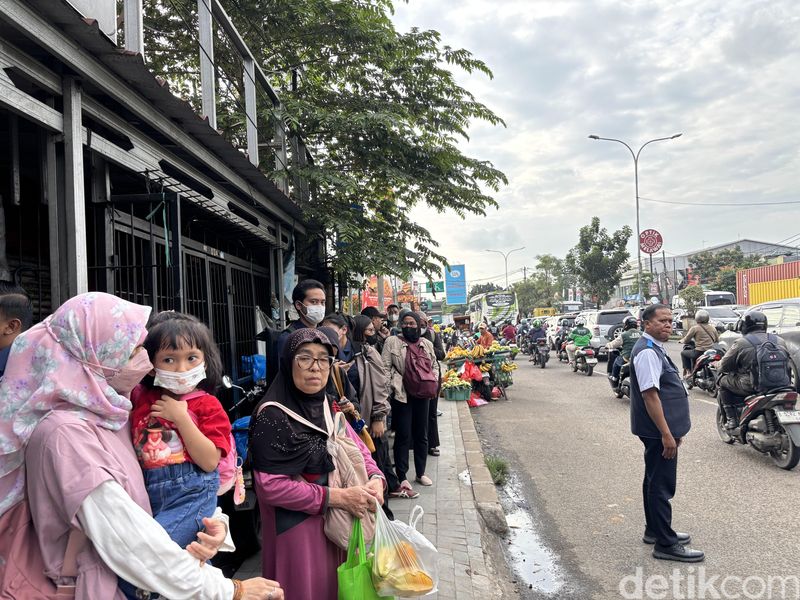 Penumpang TransJakarta di Jatiasih, Bekasi, mengantre di pinggir jalan karena tidak ada halte.