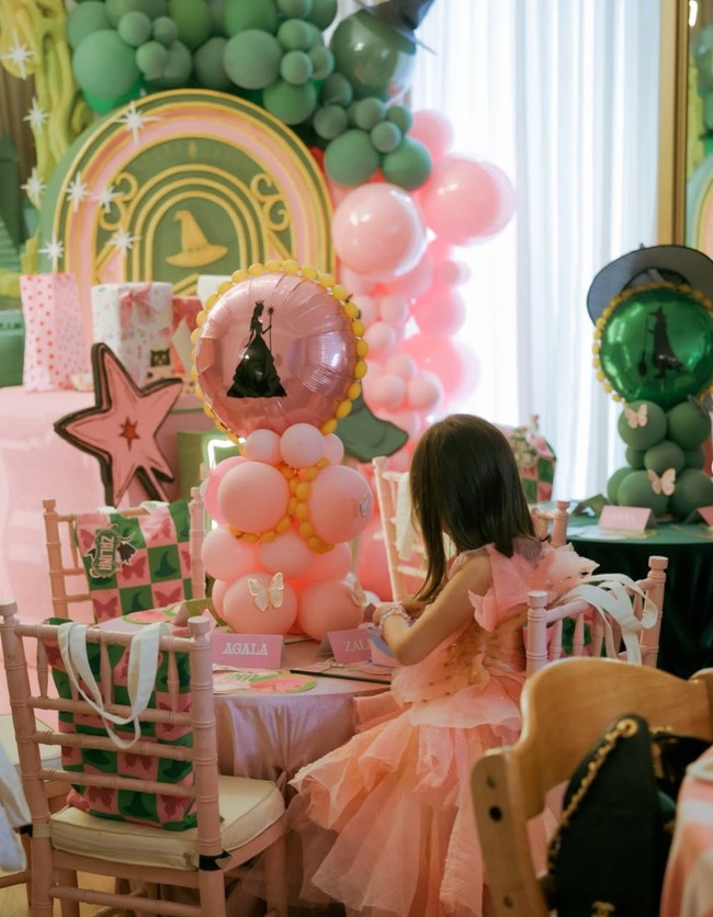 Sebagian besar dekorasi acara didominasi dengan warna pink dan hijau. Senada dengan tema tersebut, Zalina tampil bak peri mengenakan dress berwarna pink. Foto: Instagram/@raisa6690