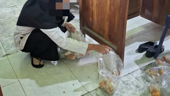 Salah satu guru membungkus MBG dengan plastik karena tas kain diminta kembali oleh SPPG.