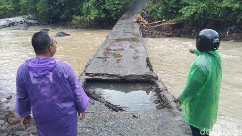 Salah satu ruas jembatan penghubung di Desa Antap, Kecamatan Selemadeg, Tabanan, jebol akibat tergerus luapan sungai Yeh Otan, Senin (23/2/2026).