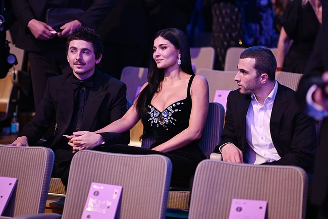 Pasangan ini terlihat mesra sepanjang acara. Fotografer menangkap momen Jenner menggenggam lengan Chalamet saat para tamu duduk di tempat masing-masing. Foto: Getty Images/Scott Garfitt