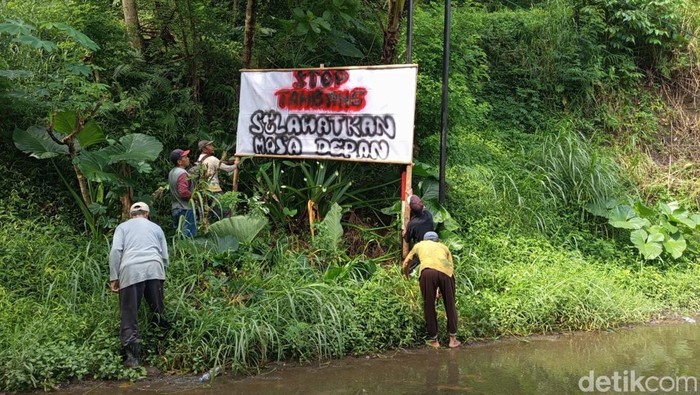 Warga Desa Sambeng, Kecamatan Borobudur, Magelang, memasang spanduk menolak penambangan tanah uruk, Minggu (22/2/2026).