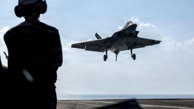 Dalam foto yang dirilis oleh Angkatan Laut AS ini, sebuah F-35C Lightning II, yang tergabung dalam Skuadron Serangan Pesawat Tempur Marinir (VMFA) 314, bersiap melakukan pendaratan dengan penahan di dek penerbangan kapal induk kelas Nimitz USS Abraham Lincoln (CVN 72) di Laut Arab pada 12 Februari 2026. (Photo by Sonny Escalante / US NAVY / AFP)