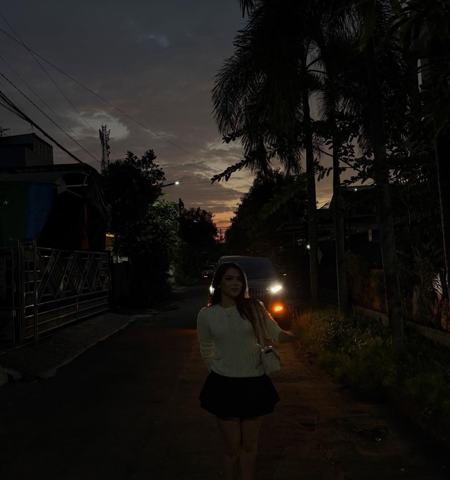 Potret Davina yang diunggah Ardhito. Terlihat artis cantik itu tampil mengenakan atasan sweater putih dan rok pendek. Ia berdiri di jalanan dengan suasana senja menjelang malam. Foto: Instagram/@ardhitopramono