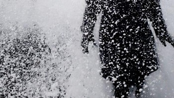 Ekspresi terkejut seorang wanita terkena ombak yang dipenuhi salju pada musim dingin. Kamera menangkap momen ledakan putih yang dramatis. Foto: Borepnada