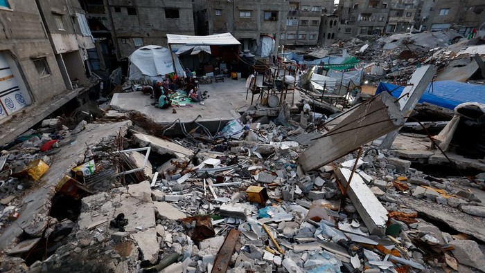 A child runs as members of the Palestinian Abu Naji family gather to break their fast by eating Iftar meals during the holy month of Ramadan, amidst the rubble of their house which was destroyed during the two-year Israeli offensive, in Gaza City, February 23, 2026. REUTERS/Mahmoud Issa