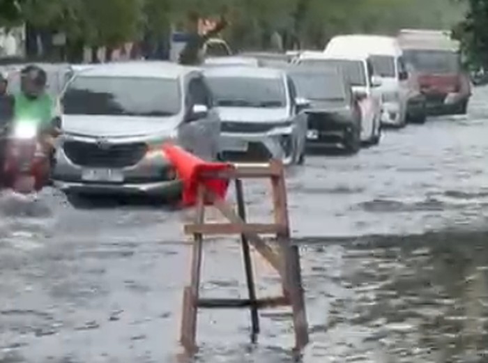 Jalan Bypass Ngurah Rai menuju Bandara Ngurah Rai dan Tol Bali Mandara tersendat dari lampu merah McD Sanur, Denpasar, akibat genangan setinggi mata kaki di bahu jalan, Selasa (24/2/2026). (I Nyoman Adhisthaya Sawitra/detikBali)