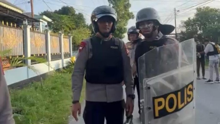 Kapolres Kota Tual, AKBP Wansi Des Asmoro (kiri) mendapat pengawalan setelah terkena panah usai menghalau bentrokan.