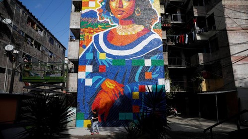 Sebuah mural unik yang terinspirasi lukisan legendaris Mona Lisa mencuri perhatian warga di Mejicanos, El Salvador. Bukan dilukis dengan cat biasa, karya seni ini dibuat dari ribuan tutup botol plastik bekas yang dikumpulkan langsung oleh warga sekitar. REUTERS/Jose Cabezas