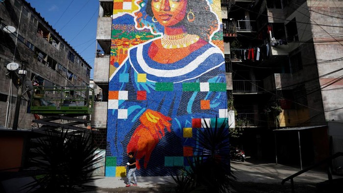 Sebuah mural unik yang terinspirasi lukisan legendaris Mona Lisa mencuri perhatian warga di Mejicanos, El Salvador. Bukan dilukis dengan cat biasa, karya seni ini dibuat dari ribuan tutup botol plastik bekas yang dikumpulkan langsung oleh warga sekitar. REUTERS/Jose Cabezas