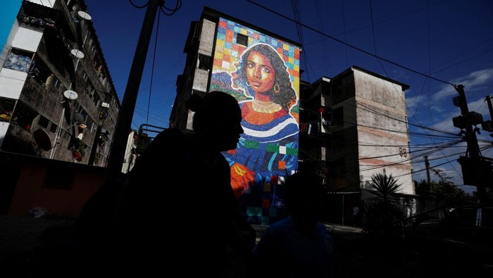 Sebuah mural unik yang terinspirasi lukisan legendaris Mona Lisa mencuri perhatian warga di Mejicanos, El Salvador. Bukan dilukis dengan cat biasa, karya seni ini dibuat dari ribuan tutup botol plastik bekas yang dikumpulkan langsung oleh warga sekitar. REUTERS/Jose Cabezas