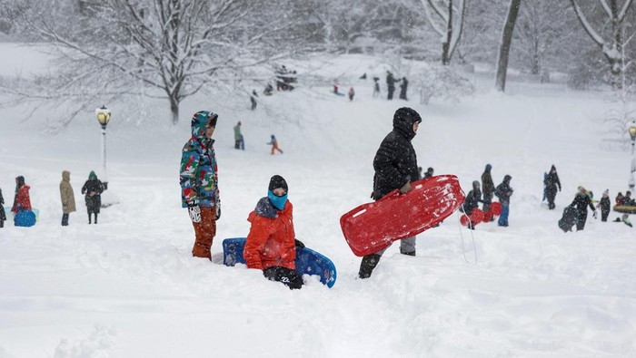 People sled in Central Park as snow falls during a winter storm in New York City, U.S., February 23, 2026. REUTERS/Jeenah Moon