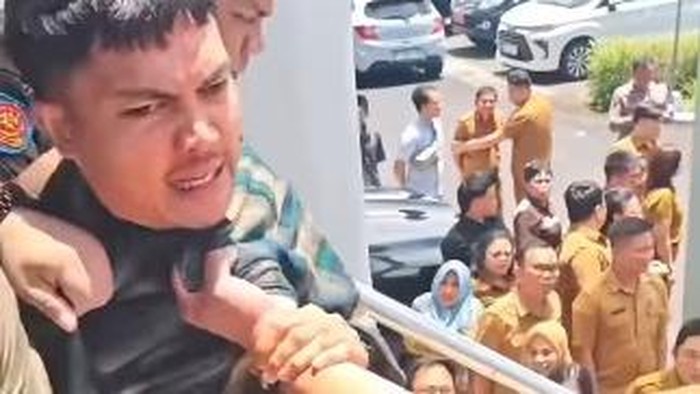 Oknum ASN menarik kerah baju pendemo saat Rapat Paripurna DPRD Sulut.