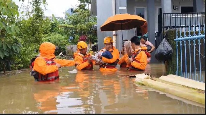 Petugas BPBD Makassar mengevakuasi bayi saat banjir merendam Kelurahan Tello Baru, Kecamatan Panakkukang.