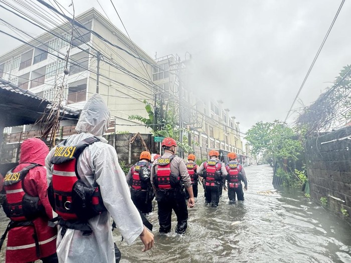 Sejumlah polisi bergerak melakukan evakuasi korban banjir di Jalan Bumiayu, Sanur, Denpasar, Sanur, (24/2/2026). (Maria Christabel DK/detikBali)
