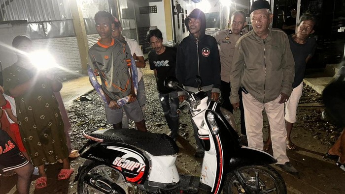 Suasana saat polisi datangi TKP dan warga amankan barang bukti motor pelaku penganiayaan di Polman.