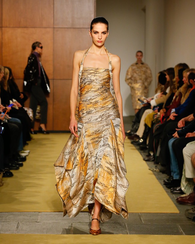 Pada lini aksesori, detail Bunny Knot hadir pada quilted shoulder bag dalam balutan kulit dan metal. Siluet soft duffle mengingatkan pada military dopp kit vintage, berdampingan dengan model baru Charlie satchel. Tas anyaman rafia dan kulit menjadi refleksi tas yang pernah dikenakan Tory semasa SMA—membuktikan bahwa memori bisa menjadi fondasi desain yang kuat. (Foto: Dan Lecca/Tory Burch)