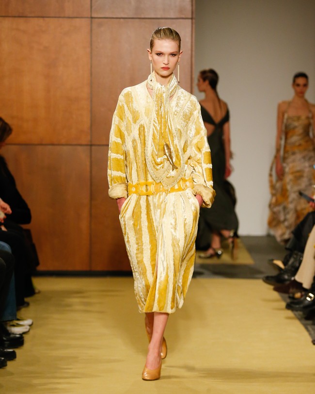 Sweater wol Shetland disikat dan dicuci hingga terasa ringan dan airy. Sementara gaun jersey dipelintir dan diikat mengikuti lekuk tubuh, menciptakan siluet yang dinamis dan feminin. Palet warna pun terasa personal. Corduroy plush dalam nuansa aprikot dan saffron terinspirasi dari gaya sang ayah, memancarkan kehangatan nostalgia yang intim. (Foto: Dan Lecca/Tory Burch)