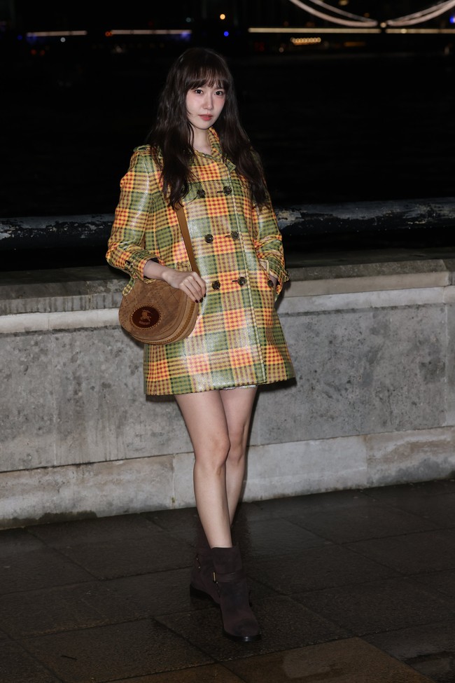 Penampilan Yoona SNSD dilengkapi dengan hand bag dan sepatu boots berwarna coklat dari koleksi Burberry. Foto: Getty Images