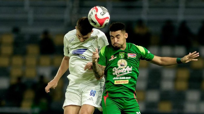 Pemain PSM Makassar Luka Cumic berduel udara dengan pemain Persebaya Surabaya Jefferson da Silva.