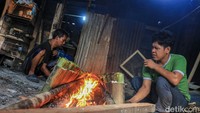 Para pekerja membuat lemang di kawasan Senen, Jakarta, Selasa (25/2/2026). Puluhan bambu berisi campuran beras ketan dan santan berjajar di area pembakaran.