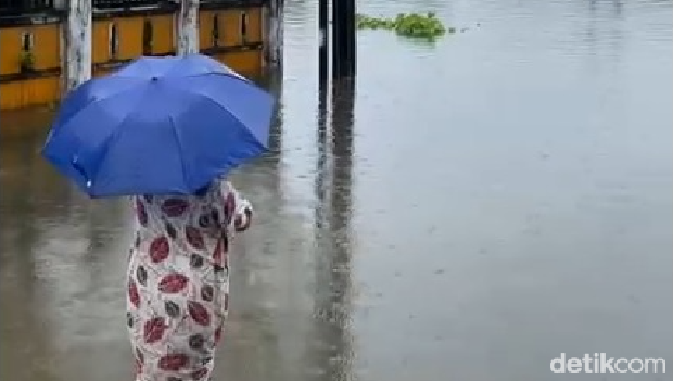 Seorang warga Perumnas Antang Makassar memantau kondisi banjir.