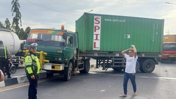 Truk Trailer yang melintang karena tak kuat menanjak di jembatan layang Trosobo, Kecamatan Taman, Sidoarjo