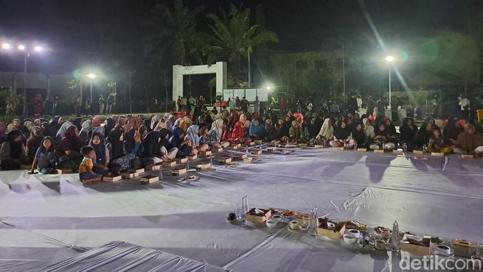 Warga lintas usia berkumpul di lapangan di depan Huntara, Aceh Tamiang, Aceh, untuk santap sahur bersama. (Agus Setyadi/detikSumut)