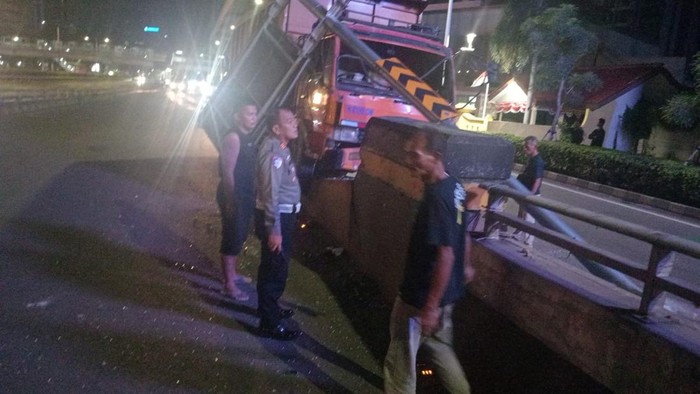 **Sopir Mengantuk, Dump Truck Tabrak Pembatas Jalan di Layang Kuningan: Kecelakaan Tunggal di Jalan Gatot Subroto**