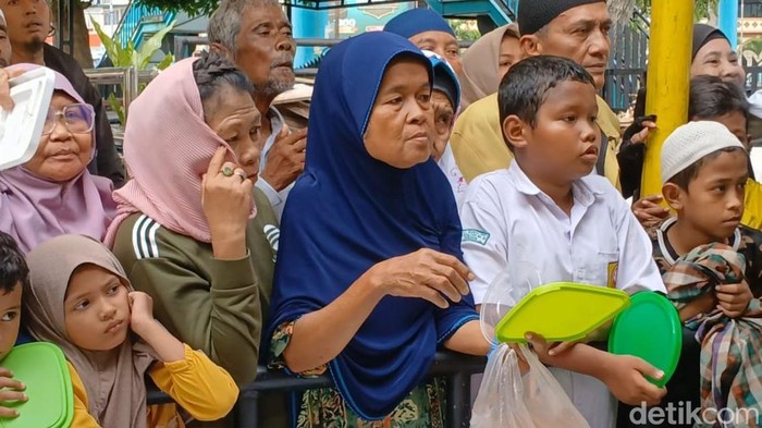 Nenek Nur mengantre bubur di Masjid Raya Medan untuk buka puasa keluarga. (Juita Sinuhaji/detikSumut)