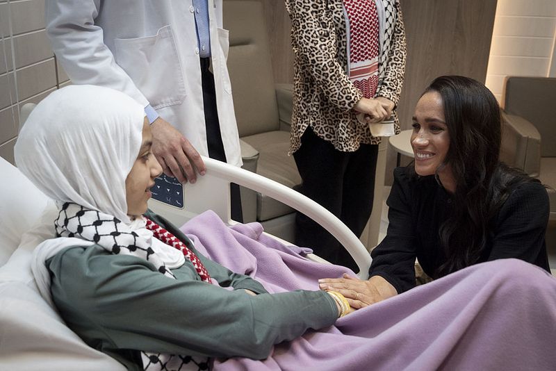 Duke dan Duchess of Sussex berbincang dengan staf medis saat bertemu Maria, seorang korban luka bakar berusia 14 tahun dari Gaza, selama kunjungan ke Rumah Sakit Spesialis di Amman, Yordania.