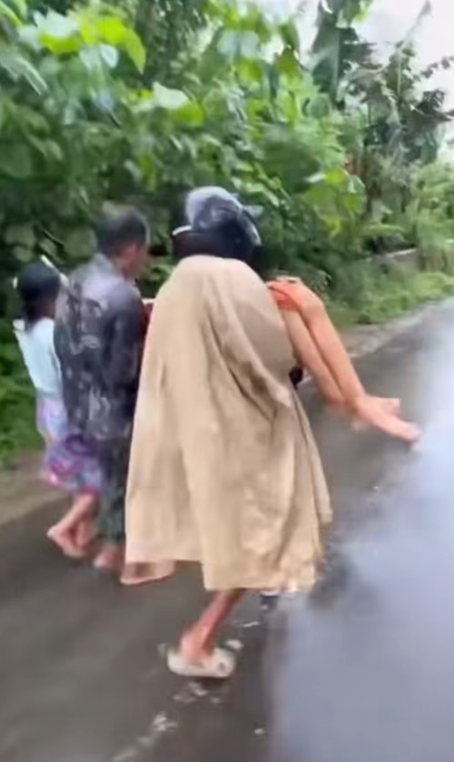 Warga sakit asma digendong tiga orang melewati jalan putus di Desa Buwun Mas, Kecamatan Sekotong, Lombok Barat, Kamis (26/2/2026). (Istimewa)