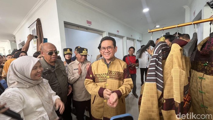 Mendag Budi saat mencoba pakaian dari pusat tekstil Tebing Tinggi. (Kartika Sari/detikSumut)