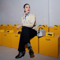 Ibu satu anak ini membawa tas tangan putih dengan detail stud metalik yang memberi aksen edgy. Sabuk hitam tipis di pinggang mempertegas siluet, sementara sepatu loafers cokelat dengan kaus kaki abu-abu menghadirkan nuansa smart-casual. Foto: Instagram/@raisa6690