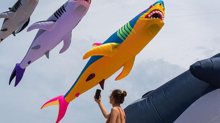 CHONBURI, THAILAND - 2026/02/26: A tourist walks near the giant whale kites on the Pattaya beach during the festival. The 2026 Beach Pattaya International Kite showcases more than 150 fancy giant kites from 12 countries around the world in Chonburi, Thailand. (Photo by Peerapon Boonyakiat/SOPA Images/LightRocket via Getty Images)