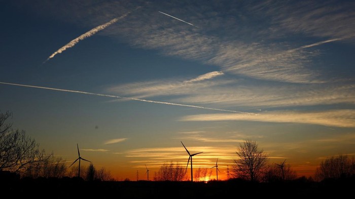 The sun sets behind power-generating windmill turbines in Halle, Belgium February 26, 2026. REUTERS/Yves Herman
