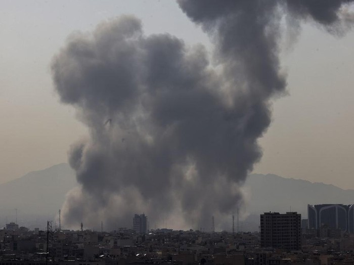 Asap mengepul di langit Teheran pada Sabtu (28/2) waktu setempat (AFP/ATTA KENARE)