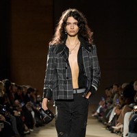 Teknik upcycling kembali menjadi sorotan. Patchwork denim daur ulang hadir dalam bentuk celana pendek, tailoring tipis dari potongan kain plaid sisa produksi, hingga detail kulit yang disisipkan di kerah dan lengan. Banyak look ditampilkan pada model bertelanjang dada, memperkuat kesan raw dan rebellious. (Foto: Isidore Montag/Gorunway.com)