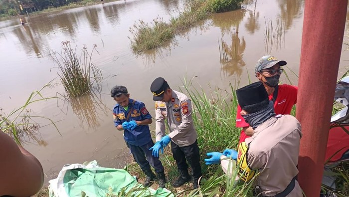 Polisi saat mengevakuasi jasad pria tanpa identitas di Banyuasin