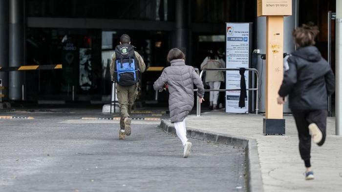 Warga Israel bergegas ke tempat perlindungan setelah sirene peringatan serangan udara berbunyi di Tel Aviv pada Sabtu (28/2) waktu setempat (AFP/JACK GUEZ)