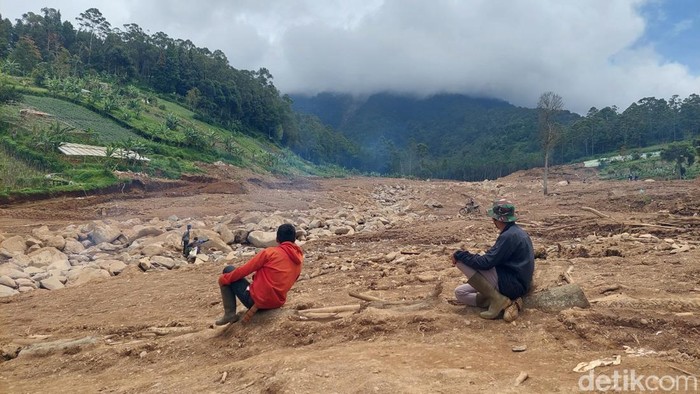 dua warga duduk di lahan bekas longsor Cisarua setelah bekerja di kebun