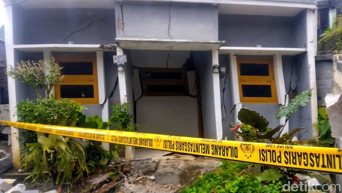 Garis polisi terpasang di sejumlah rumah yang menjadi korban pergerakan tanah, rumah-rumah itu kini terlihat sunyi bak kampung mati setelah ditinggal penghuninya mengungsi