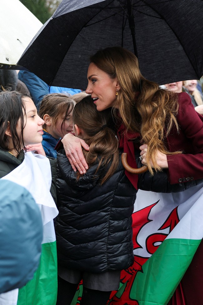 Momen manis terjadi ketika Kate memeluk beberapa anak yang menyapanya dengan antusias. Secara aturan, anggota keluarga kerajaan Inggris biasanya tidak diperkenankan melakukan kontak fisik dengan publik. (Foto: REUTERS/Phil Noble/Pool)