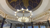Memasuki bagian dalam, pandangan dimanjakan dengan cahaya lampu yang benderang. Tulisan-tulisan kaligrafi berwarna emas terpampang di dinding dan langit-langit masjid.
