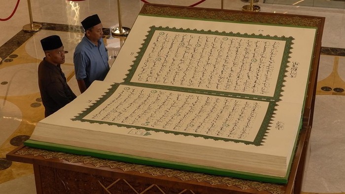 Tamu didampingi petugas mengamati mushaf kitab suci Al Quran berukuran jumbo 3 X 2 meter di Masjid Raya Sheikh Zayed, Solo, Jawa Tengah, Sabtu (28/2/2026). Mushaf tulis tangan karya Universitas Sains Al-Qur'an (UNSIQ) Wonosobo ini merupakan pemberian Presiden ke-7 RI Joko Widodo kepada pengurus masjid setempat untuk dipamerkan sebagai daya tarik bagi pengunjung dan wisatawan. ANTARAFOTO/Maulana Surya/wsj. *** Local Caption ***