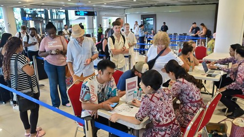 Petugas menyampaikan informasi kepada calon penumpang pesawat di area helpdesk penumpang Terminal Internasional Bandara Internasional I Gusti Ngurah Rai, Badung, Bali, Minggu (1/3/2026). Hingga Minggu (1/3/2026) siang tercatat sebanyak lima penerbangan internasional di Bandara Bali mengalami pembatalan dan penundaan keberangkatan sebagai dampak dari penutupan ruang udara di sejumlah negara Timur Tengah karena konflik AS-Israel dan Iran. ANTARA FOTO/Fikri Yusuf/rwa.