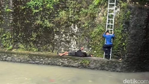 Proses evakuasi pemuda yang terjatuh di Sungai Lumintang,  Denpasar, Minggu (1/3/2026).
