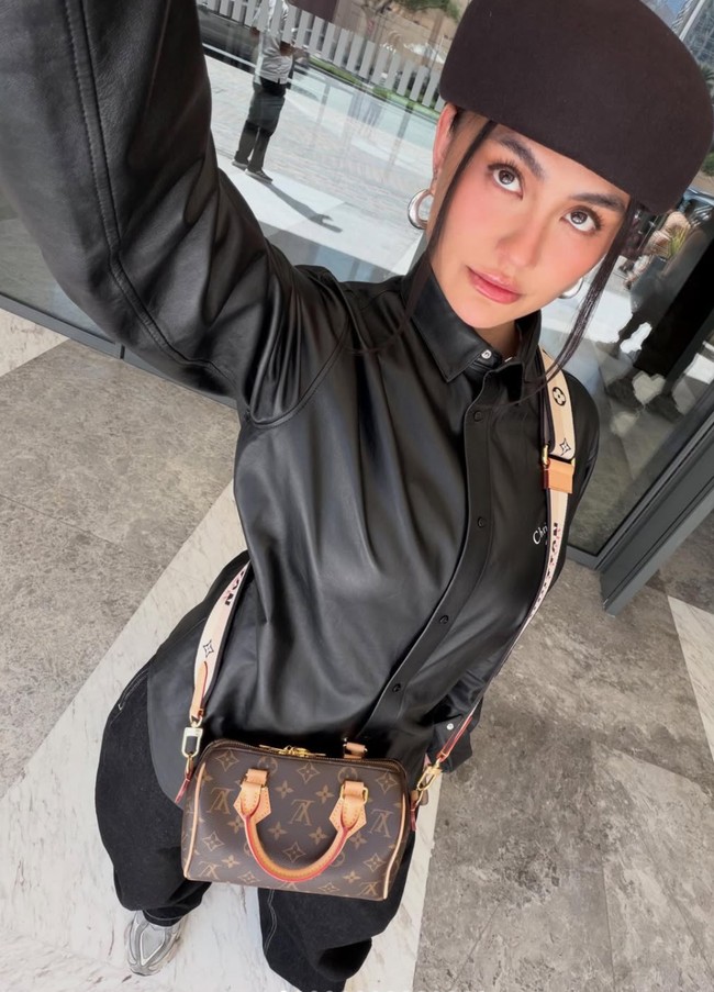 Kenakan kemeja kulit lengan panjang hitam dipadukan celana panjang senada, penampilan Agnez terlihat stylish. Ia melengkapi penampilannya dengan topi coklat dan sepasang anting hoop warna silver. Foto: Instagram/@agnezmo