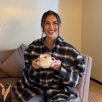 Bergaya santai, Agnez memadukan kemeja kotak-kotak oversized dengan celana jeans biru. Rambutnya tampak simpel dengan hanya diiket kebelakang dan membiarkan sedikit bagian depan rambutnya terurai natural. Foto: Instagram/@agnezmo